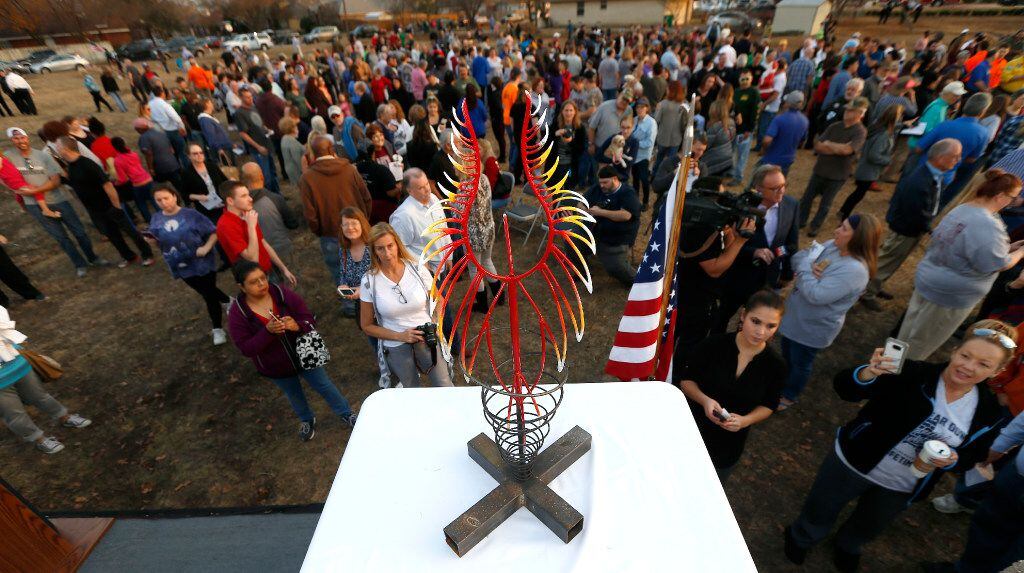 People look at a design for the 30-foot memorial sculpture "Phoenix" designed by Troy...