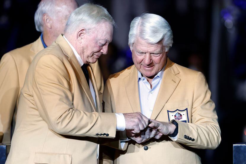 El dueño de los Cowboys de Dallas, Jerry Jones (izq), le pone el anillo del Salón de la Fama...