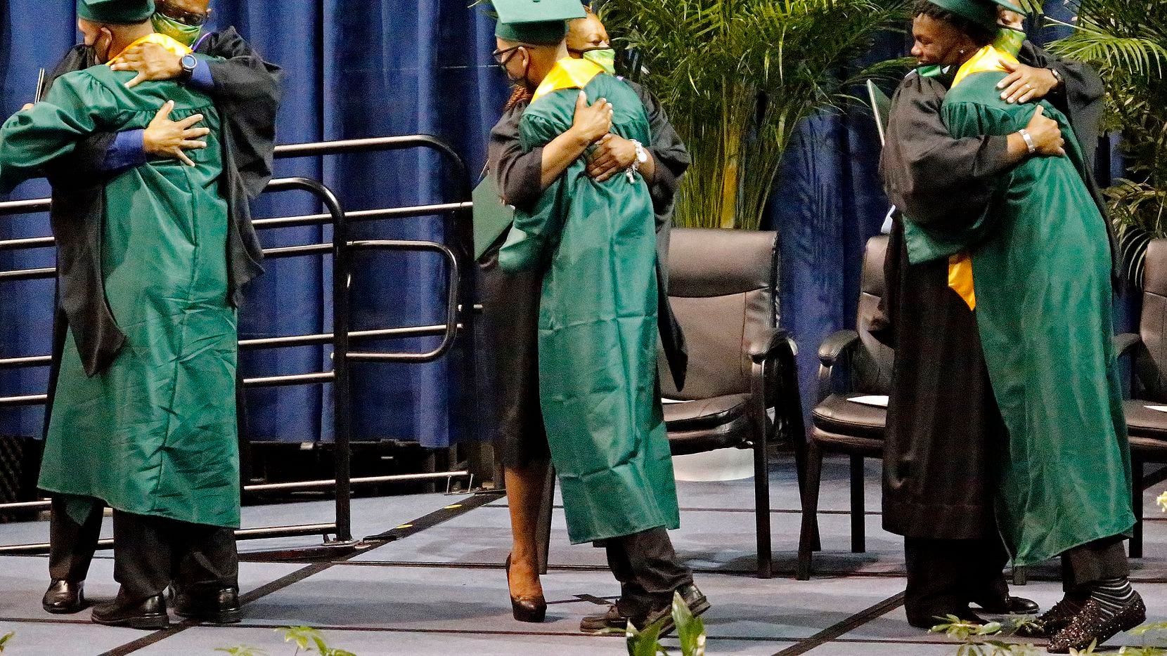Graduates embrace faculty after receiving their diplomas as Madison High School held their...