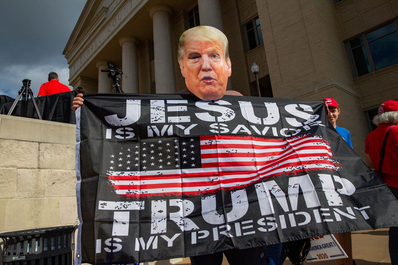 Paul Clay usa una máscara en favor del presidente Donald Trump durante la marcha America is...