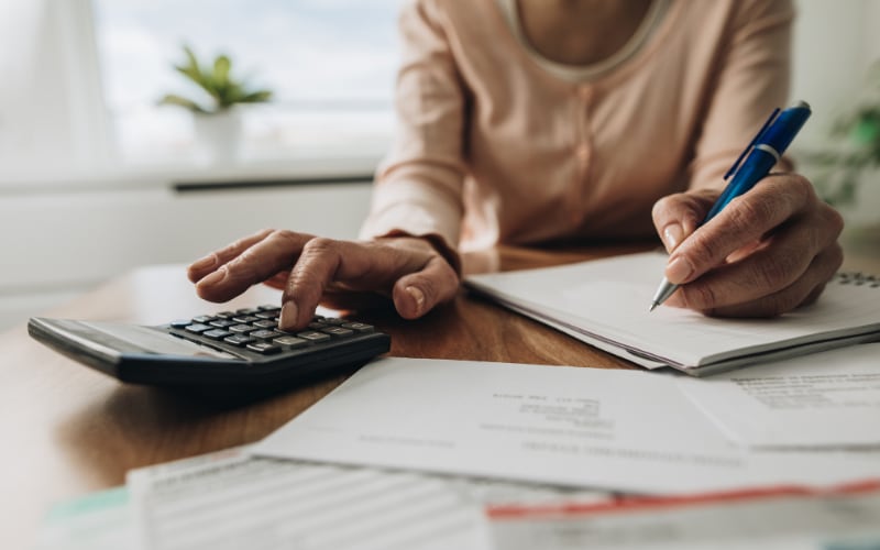 A close up of a woman calculating bills