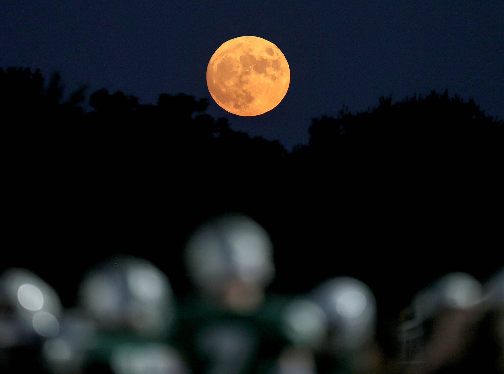 The moon sits over the game against Frisco Reedy and Frisco Lone Star in a high school...