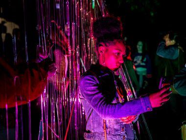 Chandler Garrison, 18, of Atlanta, takes a picture at an exhibit during AURORA in Downtown...
