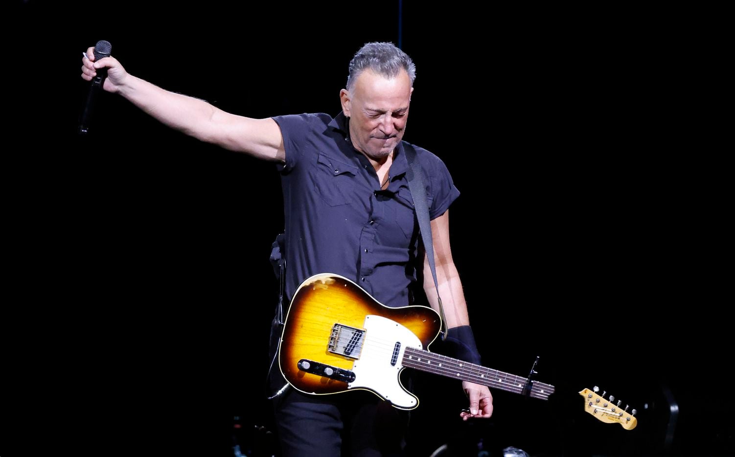 Clad in a black pearl snap shirt and black pants, Bruce Springsteen and the E Street Band...