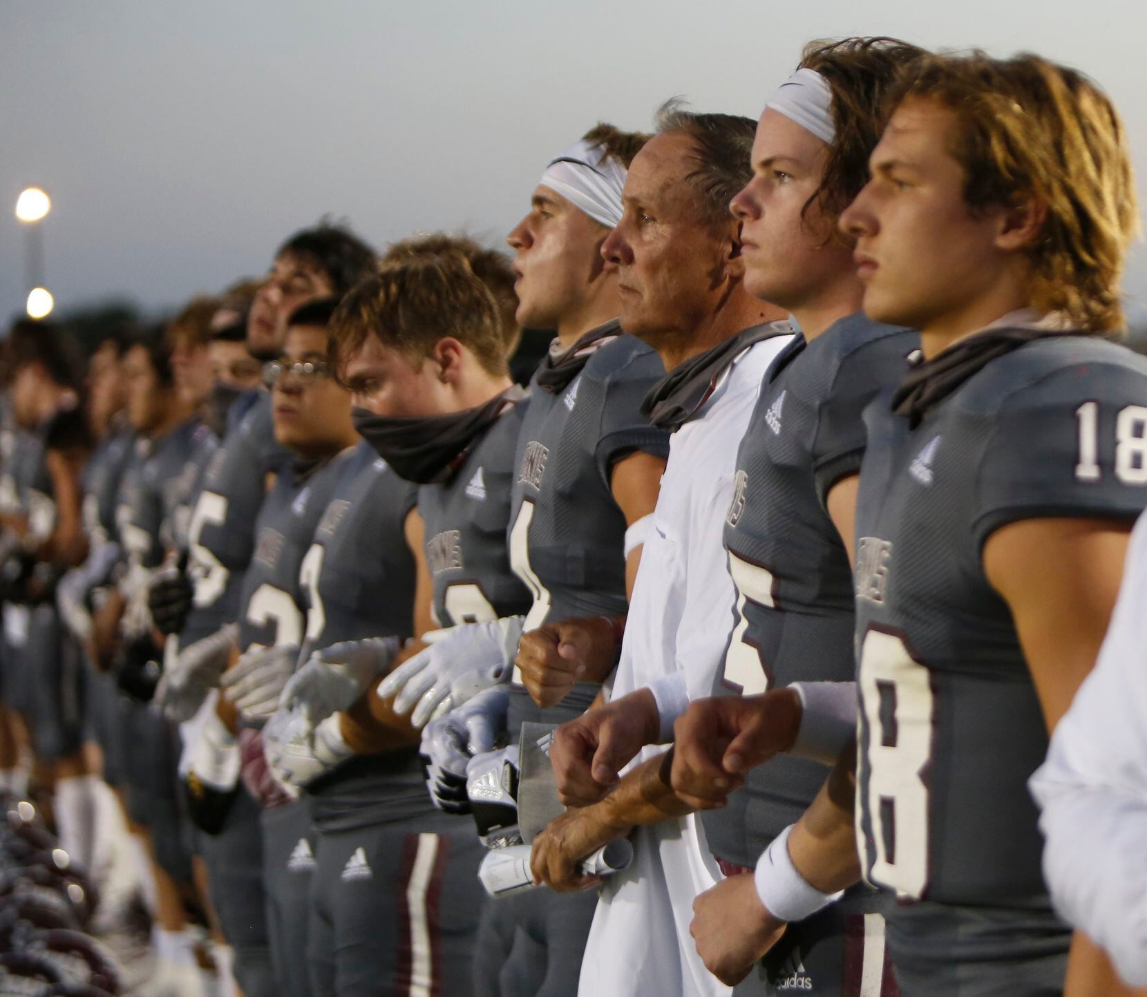 Ennis head coach Sam Harrell (3rd from right) pauses with Lions players during the playing...