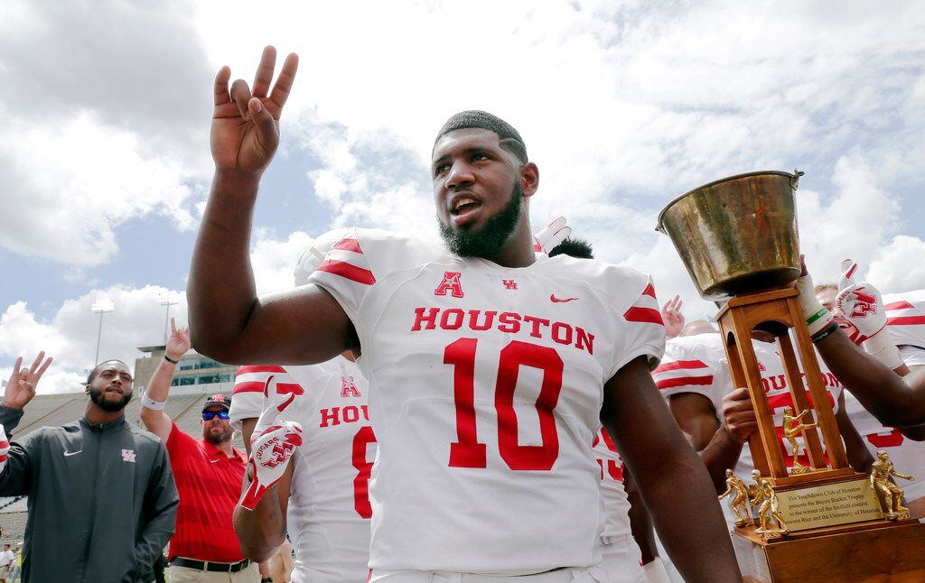 Houston Cougars defensive tackle Ed Oliver does the Cougar Paw with his teammates and the...