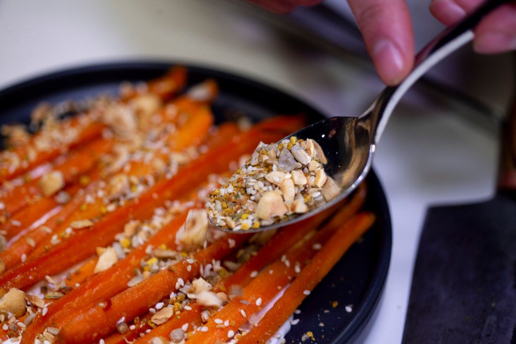 Chef Matt McCallister prepares glazed carrots with creme fraiche and seeded crumble in The...