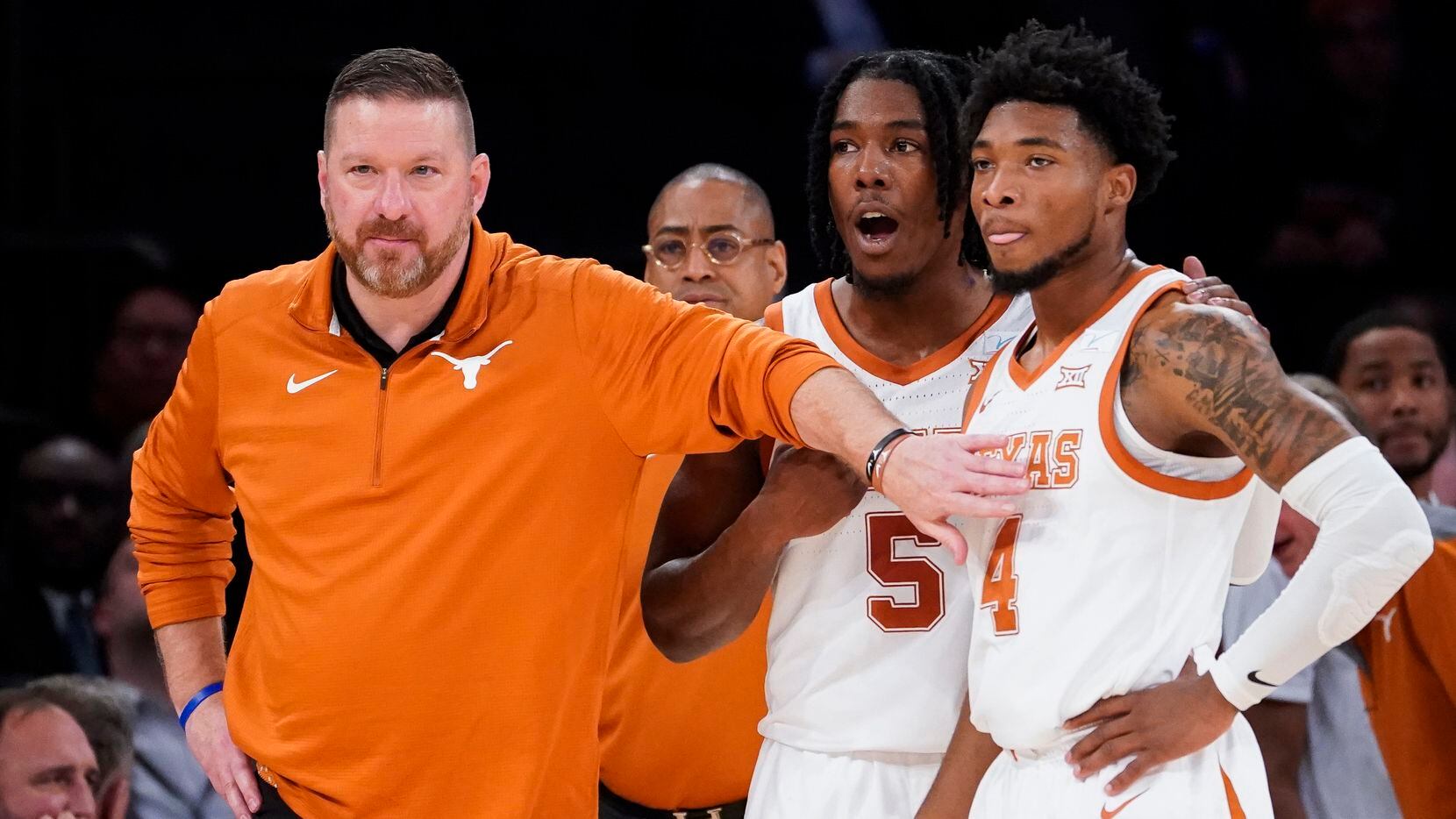 FILE - Texas head coach Chris Beard, left, meets with Tyrese Hunter (4) and Marcus Carr (5)...