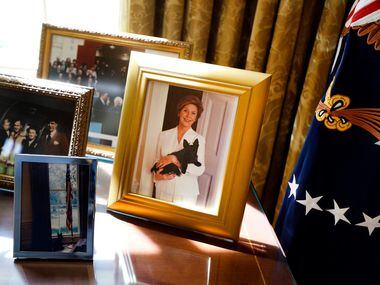A photo of former First Lady Laura Bush is on display behind the Resolute Desk in the Oval...