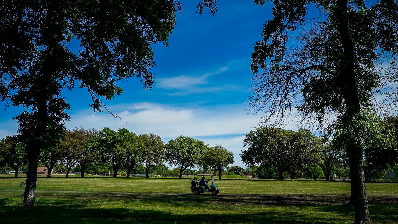 A golfer drive a cart along a fairway at Golf Club of Dallas on Wednesday, April 1, 2020, in...
