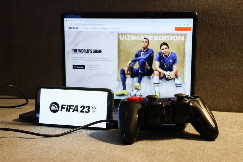 El sitio web de FIFA 23 en la pantalla de una computadora portátil, un teléfono y un gamepad.