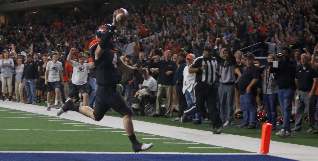 Aledo quarterback Jake Bishop (4) raises the ball over his head and ignites Bearcats fans as he scored the game winning touchdown on a 17-yard scamper to defeat Ennis, 43-36 in overtime to advance. The two teams played their Class 5A Division ll Regional final playoff football game at Frisco Center at The Star in Frisco on December 6, 2019. (Steve Hamm/ Special Contributor)