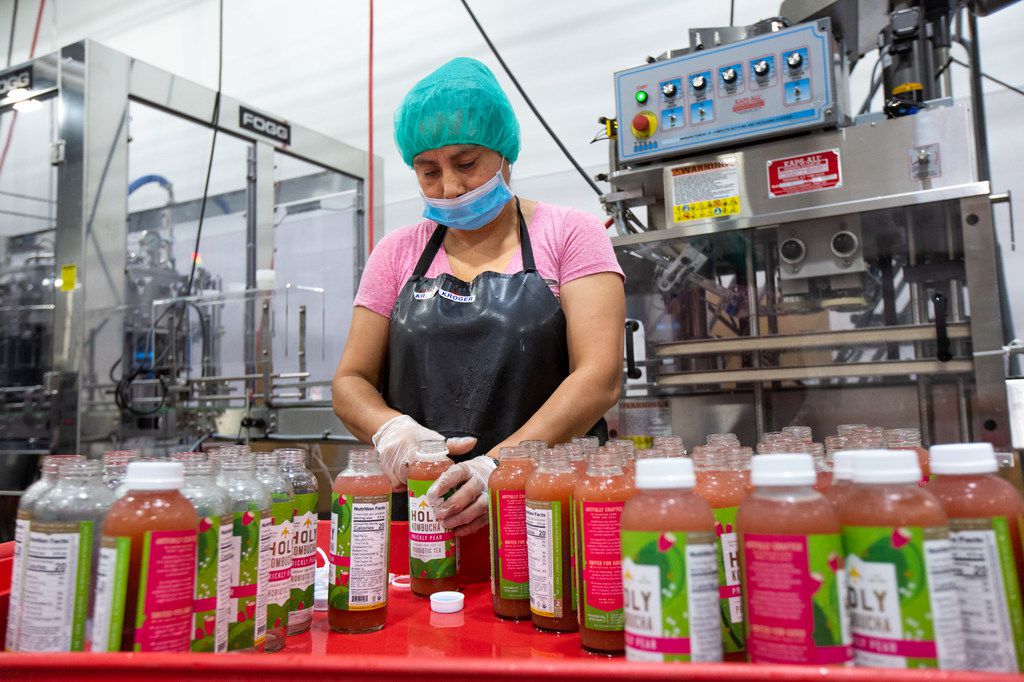 Silvia Guerra helps to package bottles of locally brewed Holy Kombucha at the brand's...