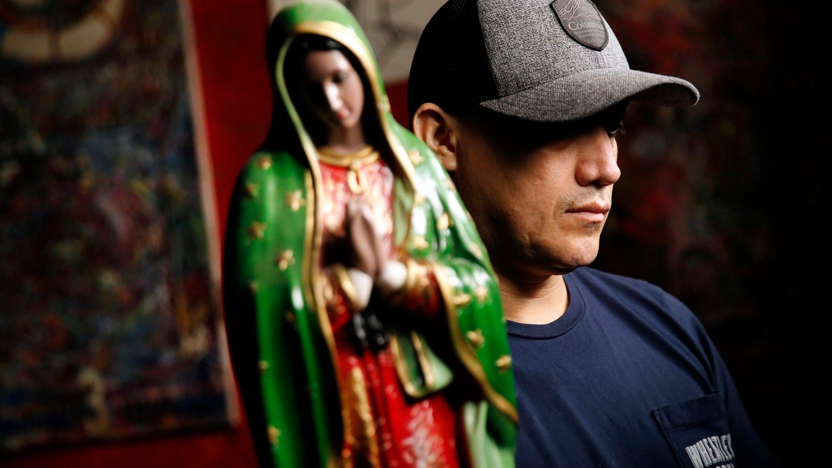 Juan, an undocumented worker, husband and father of four, is pictured with a statue of the Virgin of Guadalupe at a restaurant and bar in Dallas. He said the Virgin is his favorite santos to pray to. During the coronavirus pandemic he is only working roughly half of his full-time hours as a cook and chef. But unlike other employees with legal status in the U.S., he can't apply for unemployment benefits.