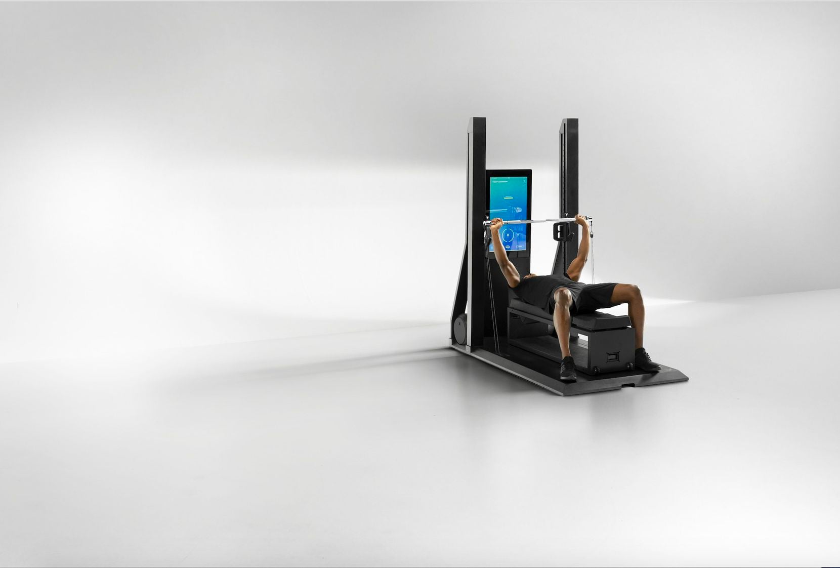 The XS1 is OxeFit's first consumer-focused smart home fitness solution that includes a 32-inch touchscreen. The bench press feature modeled in the picture allows for up to 250 pounds of weight resistance.