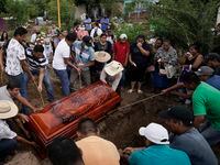 Residents bury Wilmer Rojas the day after he was killed in a mass shooting in San Miguel...