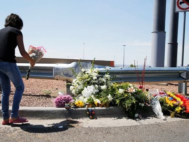 Leilani Hebben, 11, of El Paso leaves flowers near an entrance to the Walmart.
