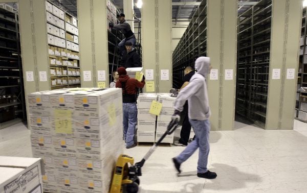 Workers hauled document boxes from George W. Bush’s presidency into storage at a Lewisville...