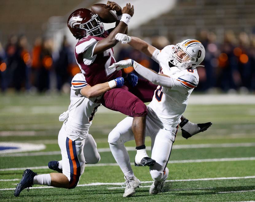 Mansfield Timberview running back DeMaury Moore (24) hangs onto the ball as he’s sandwiched...