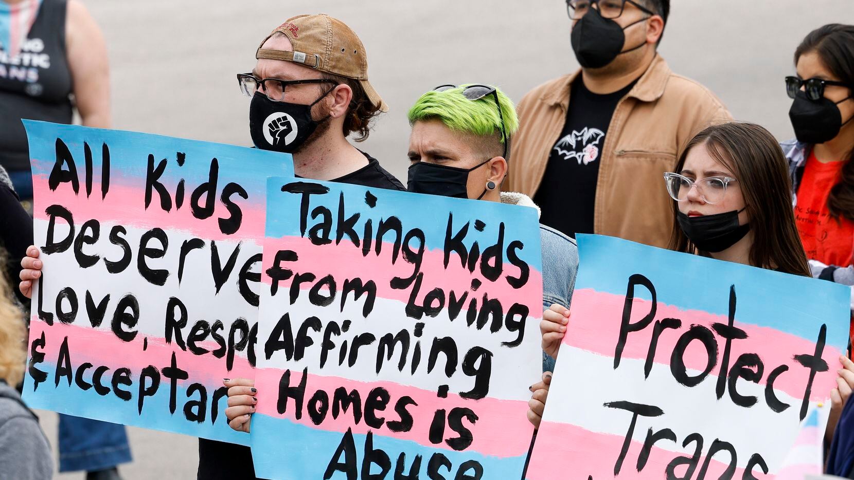 "Los niños trans imploran ayuda" dice uno de los carteles durante una protesta contra el...