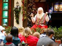 Santa Claus cuenta una historia a los niños reunidos frente a su casa de campo en NorthPark...