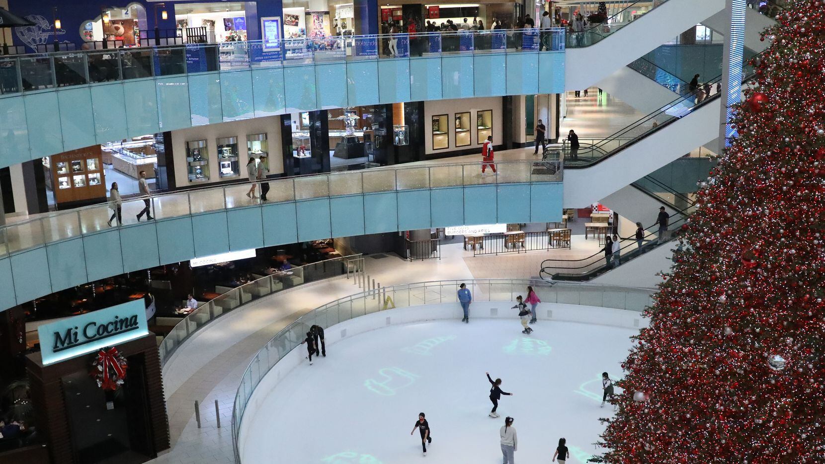 The Dallas Galleria's 95-foot tall tree sits in the center of the mall's ice skating rink as shoppers walk by and skaters spin around the rink on November 18, 2021. (Liesbeth Powers/Special Contributor)