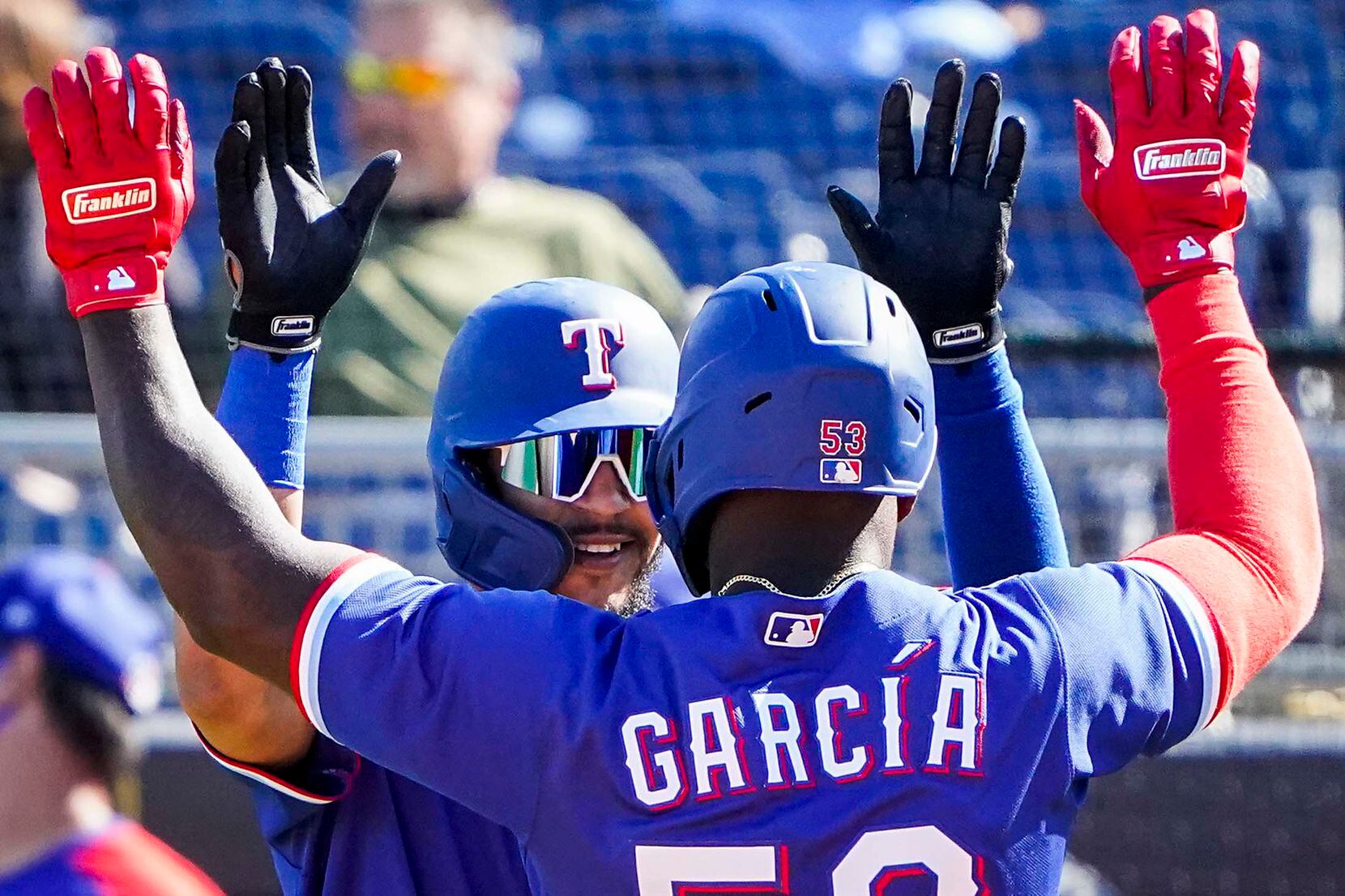Texas Rangers infielder Anderson Tejeda (facing) celebrates with outfielder Adolis García after Garcia drove in Tejada with a 2-run home run during the fifth inning of a spring training game against the Seattle Mariners at Peoria Sports Complex on Wednesday, March 10, 2021, in Peoria, Ariz.