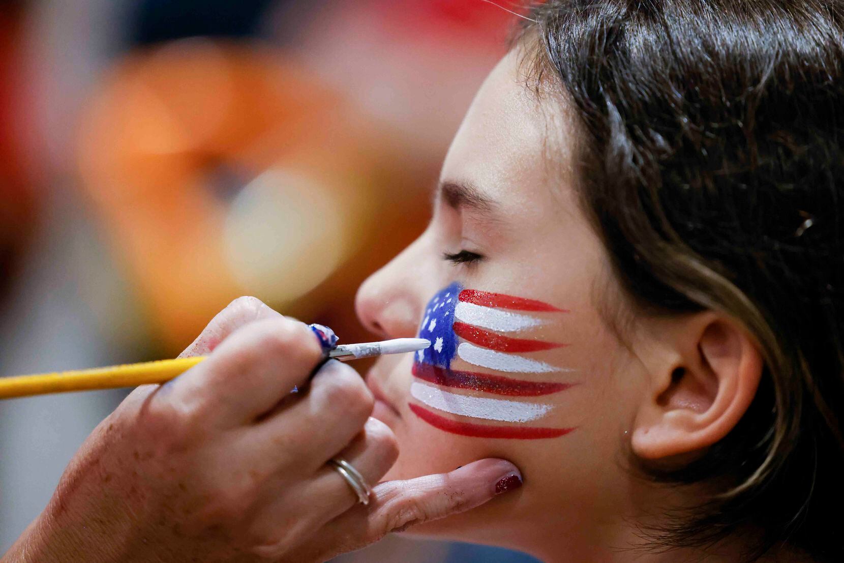 Ella Gallardo, 11, gets face paint of a U.S National flag during an Independence Day...