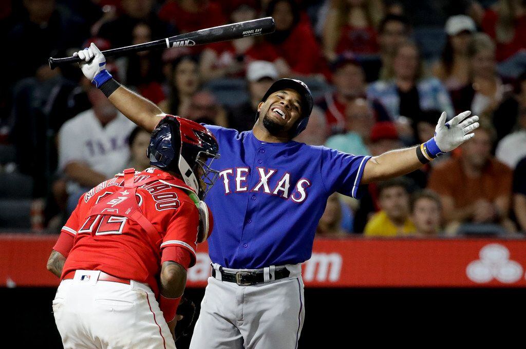 Texas Rangers' Elvis Andrus, right, reacts after striking out, next to Los Angeles Angels...