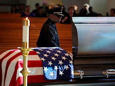Dallas police Chief David Brown places his hand on a casket for slain Dallas police Sgt....