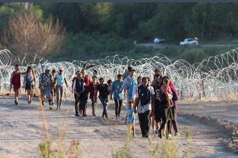 Migrants walk to a U.S. Border Patrol processing center under International Bridge II in...