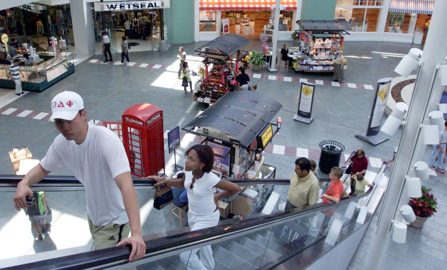 Shoppers ride the escalator at The Parks Mall in Arlington.