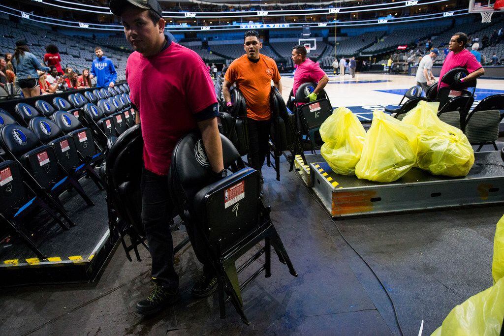 Crews remove chairs from the court after the Dallas Mavericks beat the Denver Nuggets 113-97...