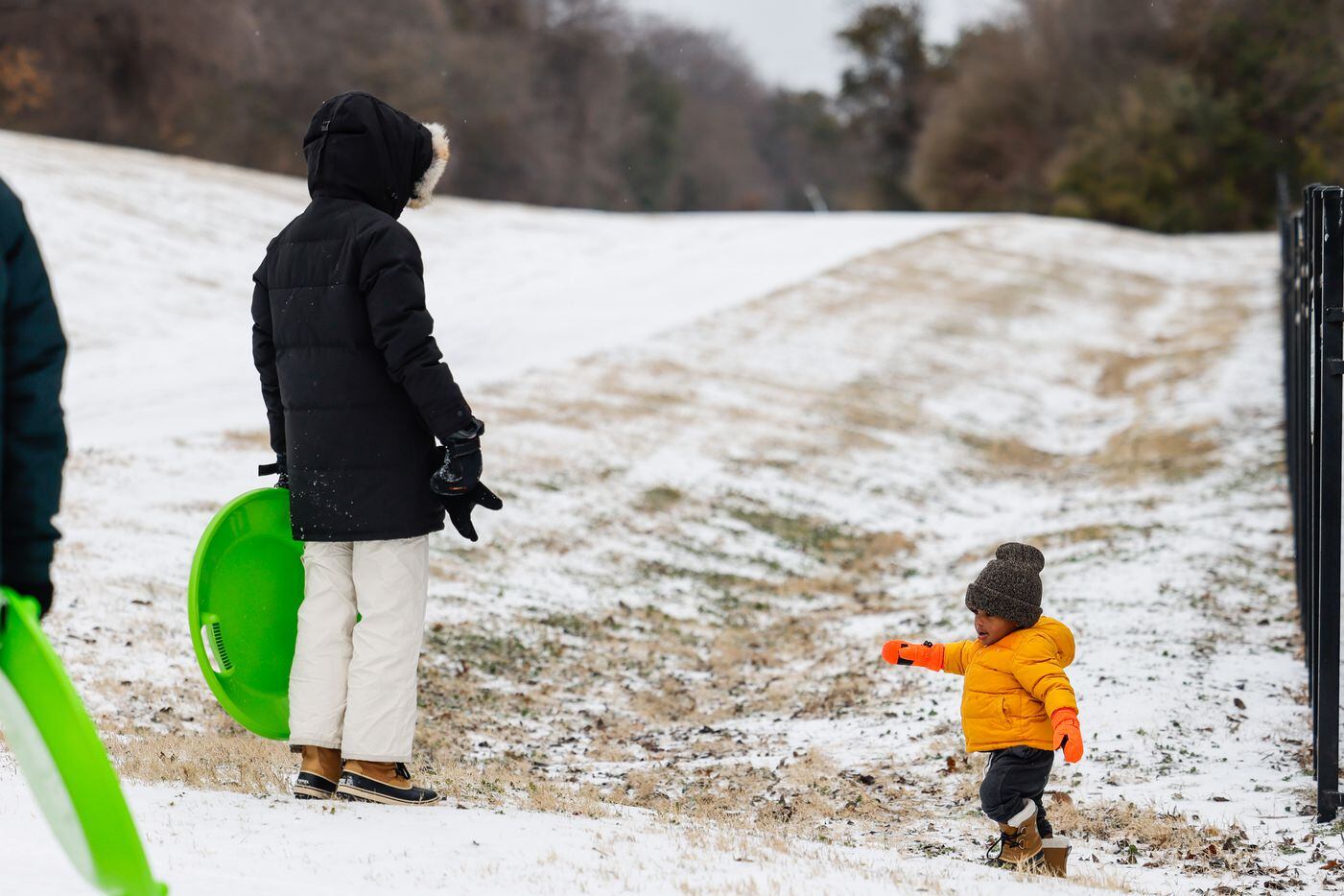 Lauren Jarret, 34, with Wesley Jarret, 1, as they play with sleet near at White Rock Lake in...
