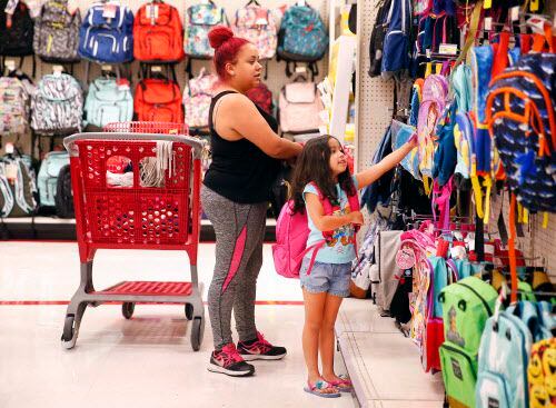 Kristie Díaz, residente de Dallas ayuda a su hija Aubrie, 5, a recoger una mochila en...