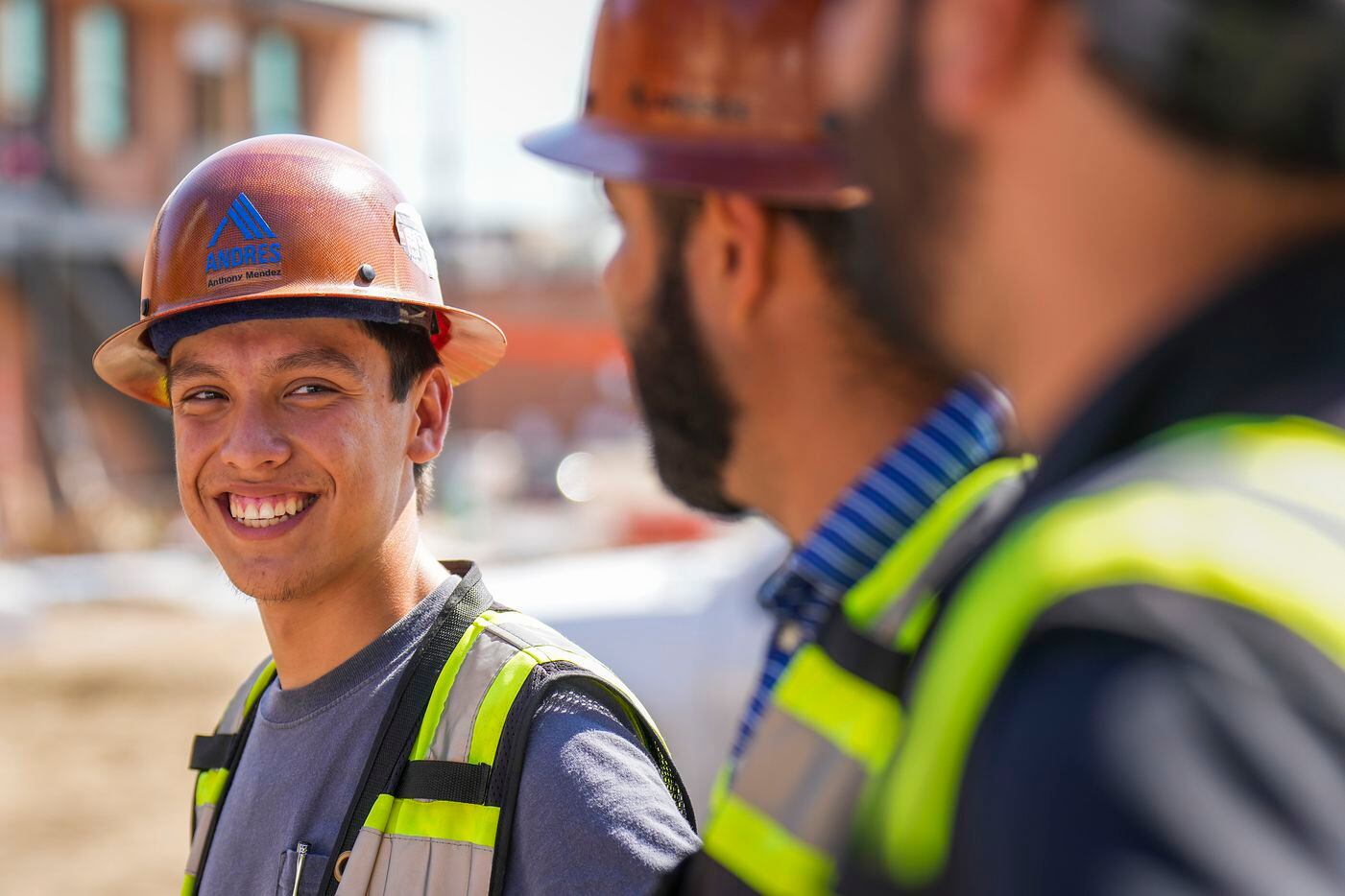 Anthony Mendez (left) talks with Andres Construction co-workers at a job site in Deep Ellum.