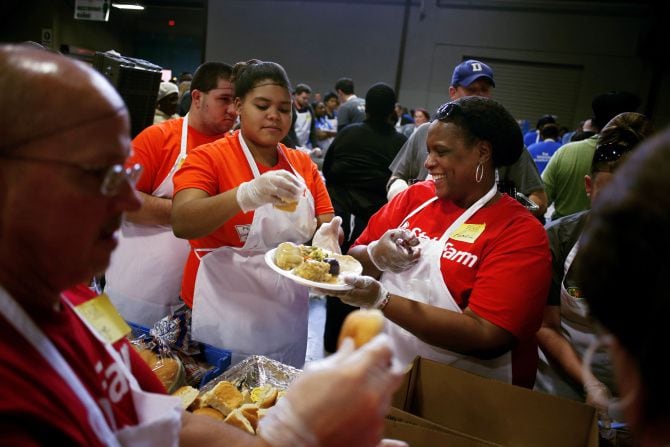 Volunteers Lillie Standford (left) and Pamela Wilson help plate food during the Dallas Feast...