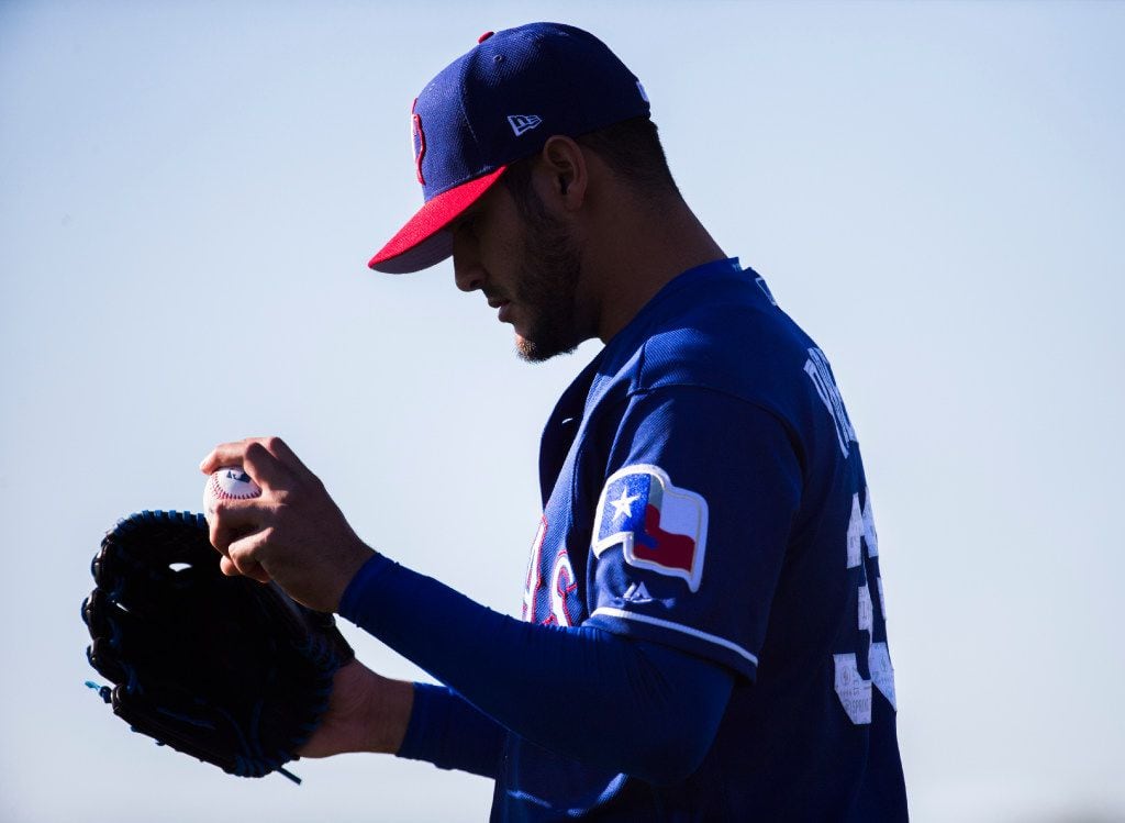 Texas Rangers starting pitcher Martin Perez (33) prepares to pitch during a spring training...