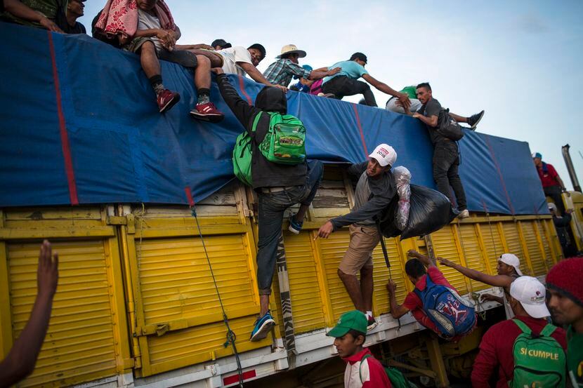 Migrantes trepan un caminón de transporte en Tatanatepec, en Oaxaca, en su trayecto al norte...