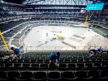 Crews clean seats on the upper concourse at the Texas Rangers' new Globe Life Field as preparations for an upcoming concert are made on the stadium floor on Wednesday, March 11, 2020, in Arlington.