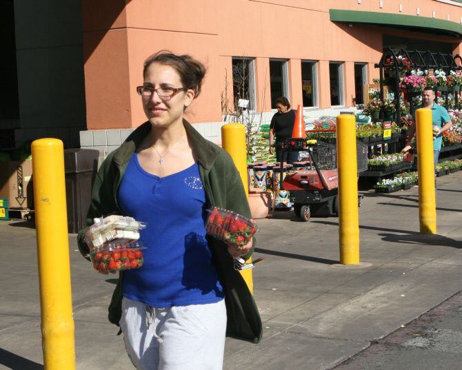 Kellie Fineman, a University of Texas senior, carries her purchases in her hands after...
