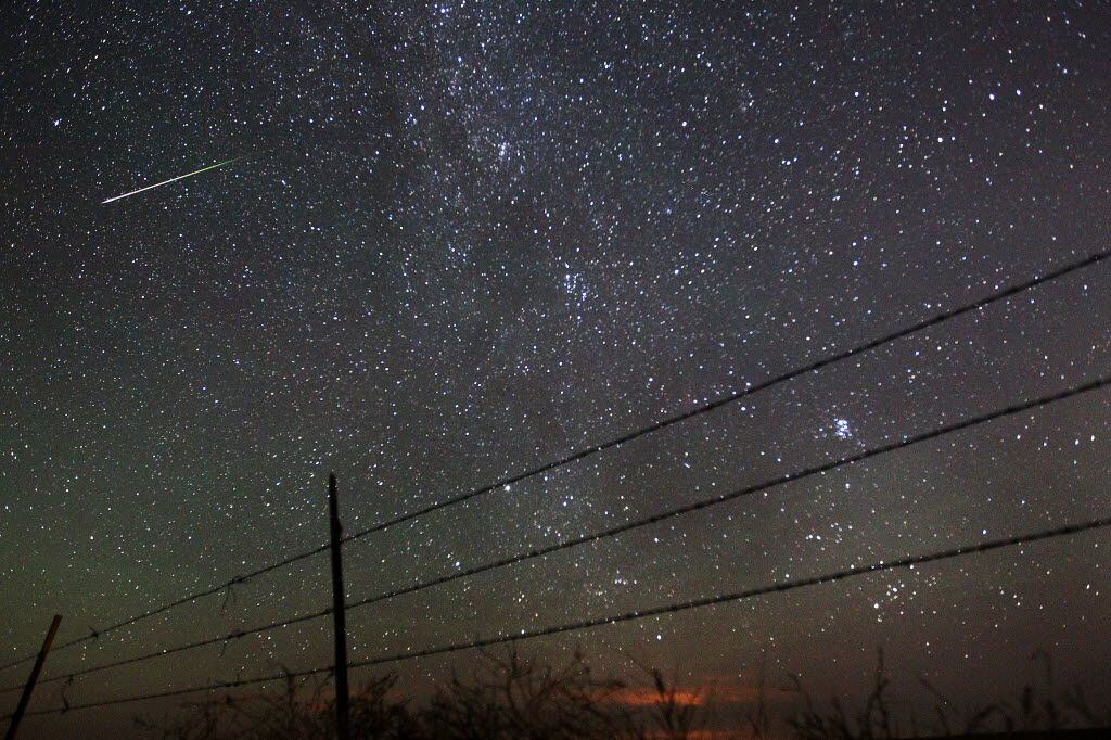 A meteor streaks above the Wyoming countryside on Aug. 13, 2013, during a Perseids meteor...