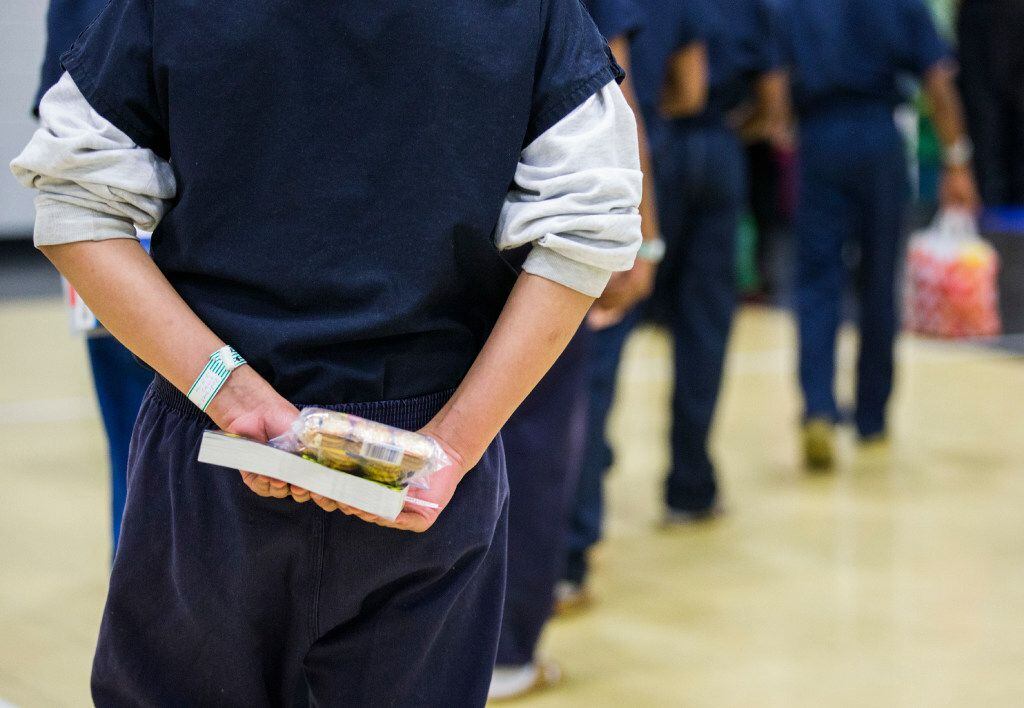 A juvenile inmate held a book and a snack while lining up to leave a Christmas lunch in December at the Jerome McNeil Juvenile Detention Center in Dallas. (Ashley Landis/Staff Photographer)