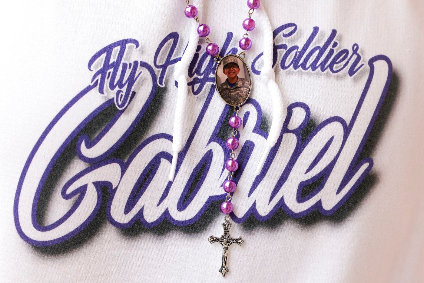 A necklace with a photo of late Grabiel Zamora, 14, hangs over the hoodie of his father...