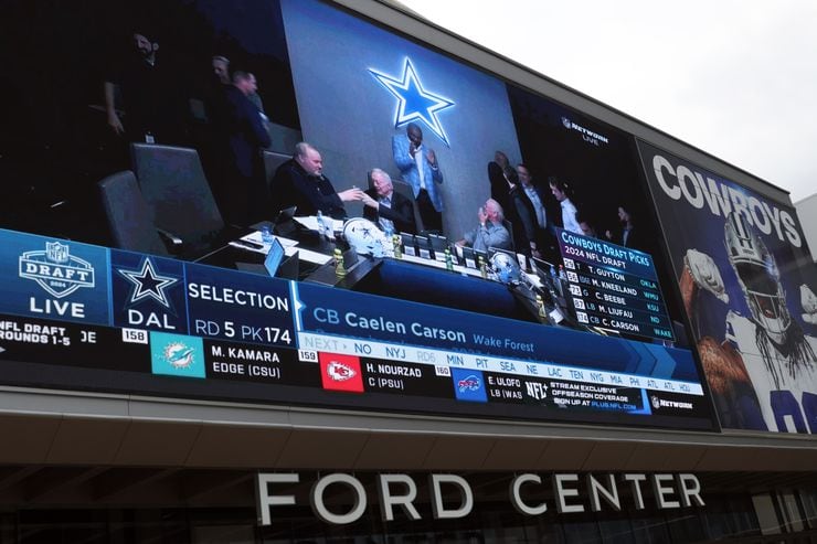 A large video screen over the entrance doors to Ford Center projects Dallas Cowboys owner...