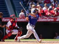 Texas Rangers' Corey Seager, right, hits a home run during the fifth inning of a baseball...
