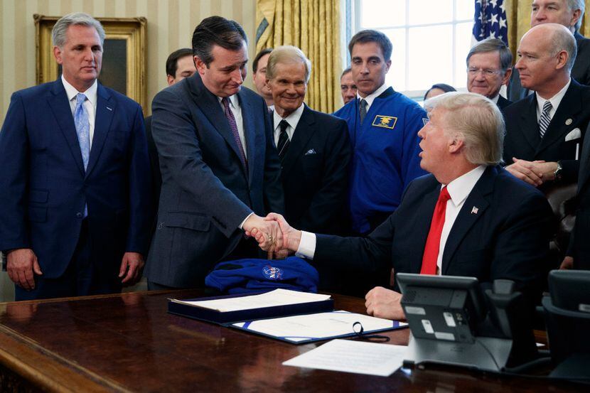 President Donald Trump shakes hands with Sen. Ted Cruz, R-Texas, flanked by House Majority...