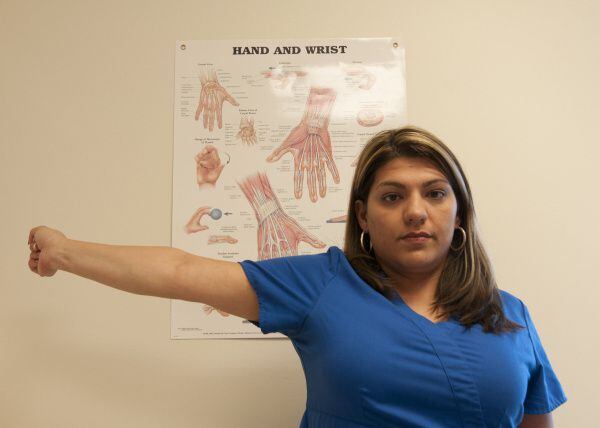 Brenda Alvarez demonstrates Step 10 of an arm exercise to alleviate hand pain.