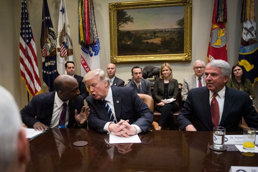 Ken Frazier, chairman and chief executive of Merck, speaks with President Trump during a...