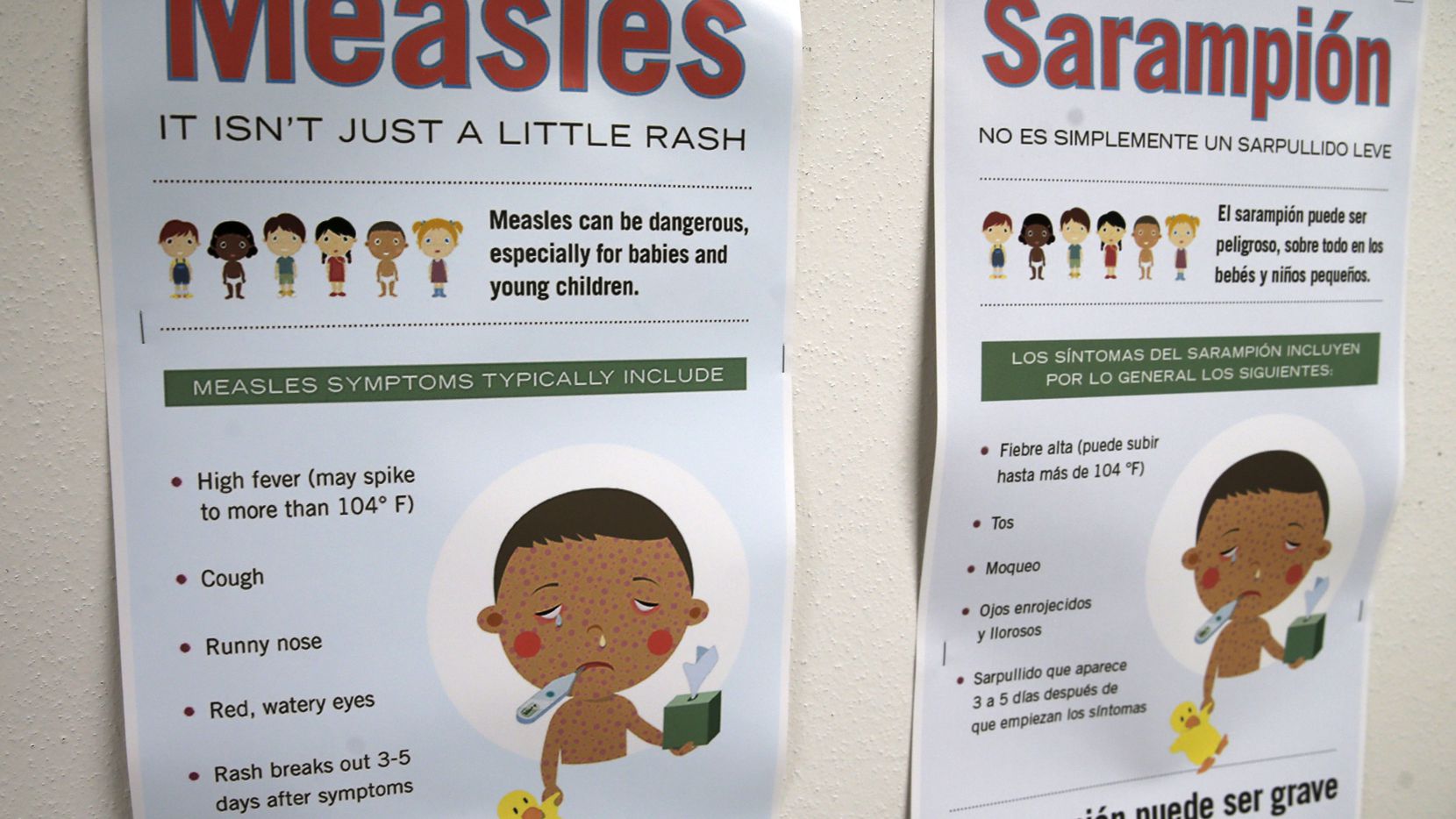 Measles vaccination posters are shown in English and Spanish at the Dallas County Health &...